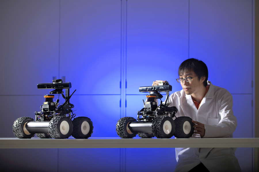 Researcher calibrating autonomous ground rovers in the KUCARS laboratory
